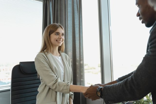 two people shaking hands over a chair