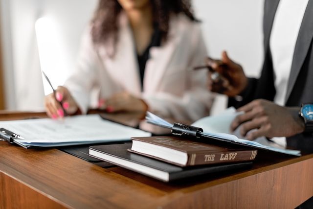 two people sitting at a table with a book labelled law