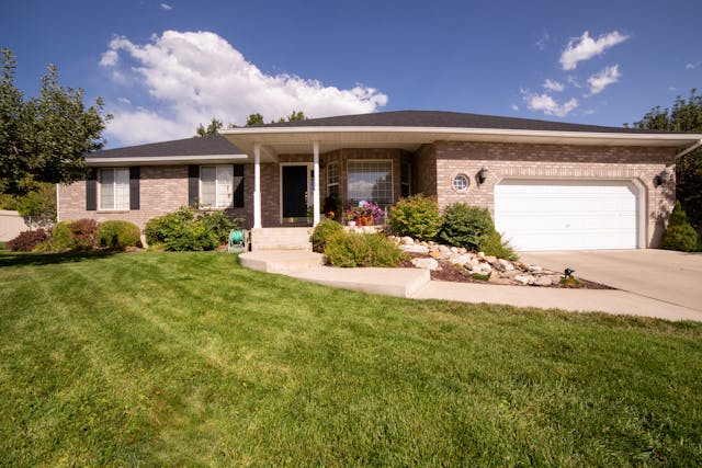 a home with a manicured lawn flower beds and clear walkways