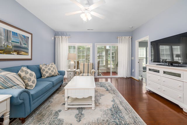 a living room with white cabinets a blue couch and white throw pillows