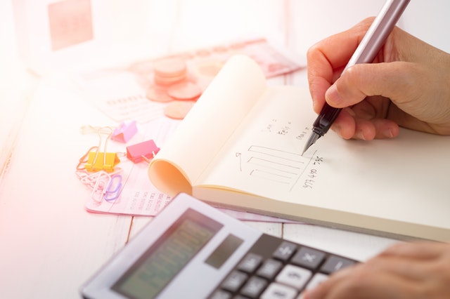 close-up-of-someone-using-a-calculator-and-notebook-to-create-a-financial-plan