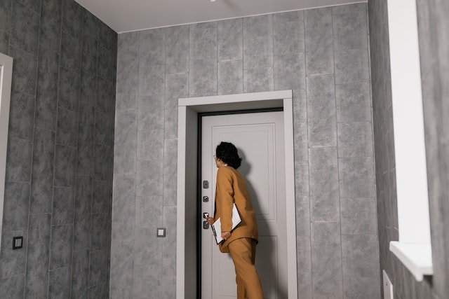 landlord in brown suit knocking on a door