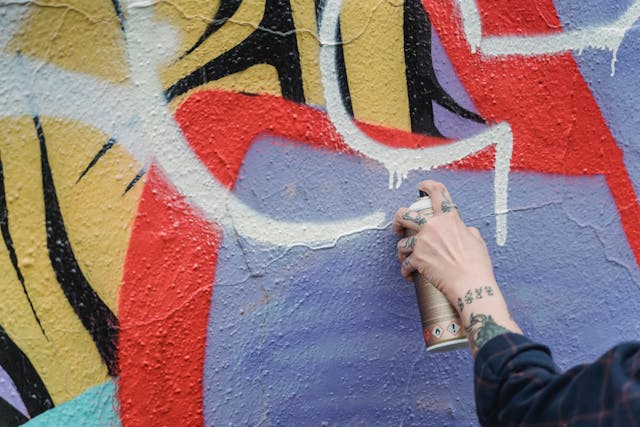 person spray painting a wall