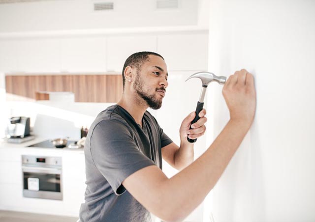 person-hammering-nail-into-wall