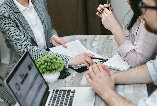 two tenants meeting with a property manager in their office looking over lease contracts