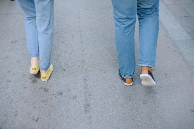 Two people walking on pavement path